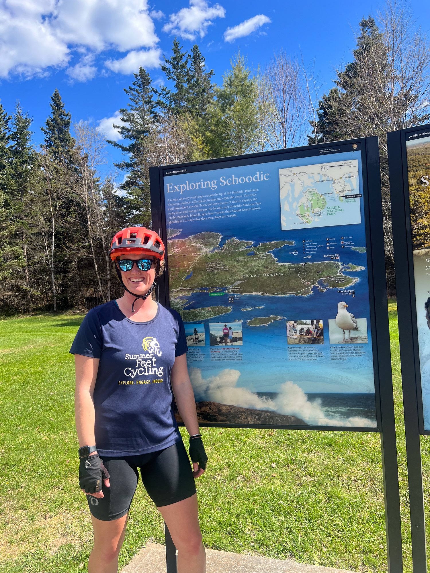 Mackenzie, one of Summer Feet Cycling's guides, in front of a map of Schoodic Peninsula