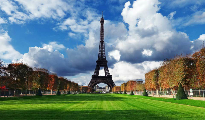 The famous Eiffel Tower towering in Paris in front of a large field of green grass