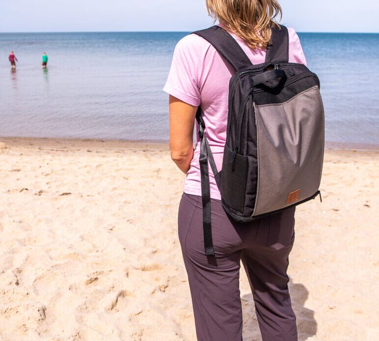 woman standing on beach with driibe backpack on