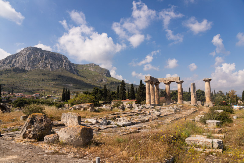 ruins of temple of apollo with acrocorinth rock in the background