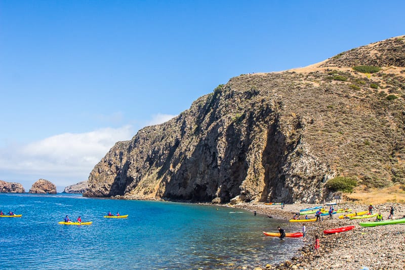 cliffs next to water with kayakers in it