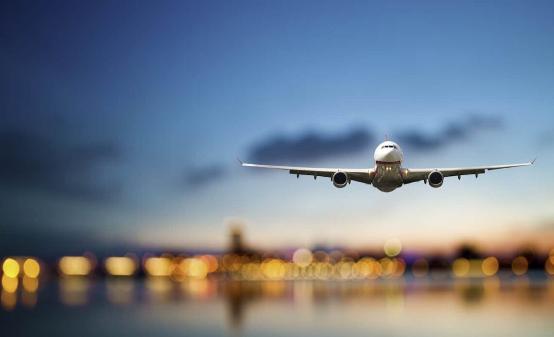 A huge commercial airline coming in to land against a bright blue sky