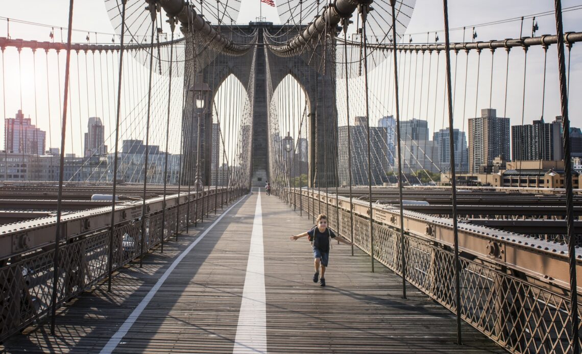 Boy running on Brooklyn Bridge,  New York City