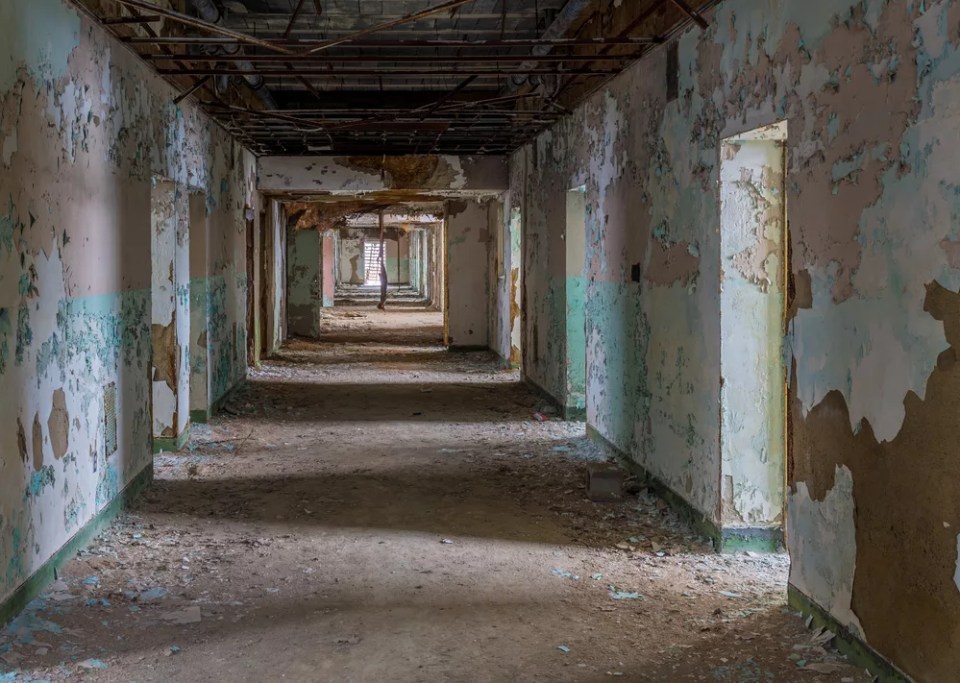 Empty rooms off long corridor inside Trans-Allegheny Lunatic Asylum in Weston, West Virginia, USA