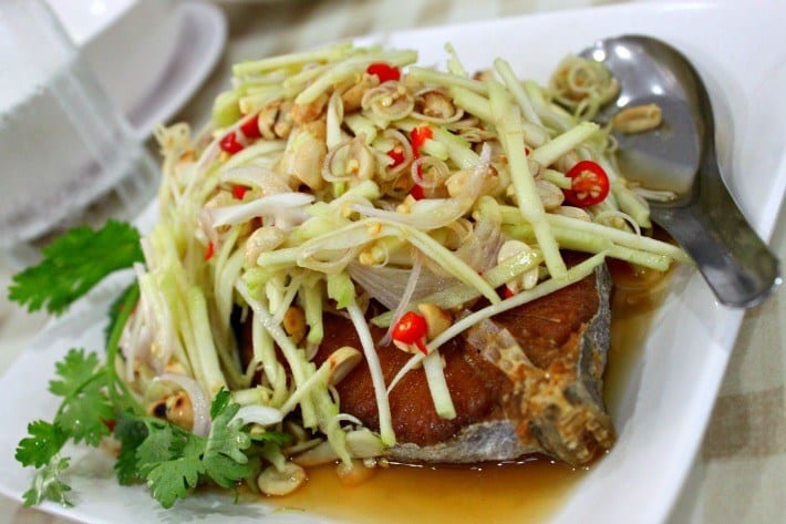 plate of fish with papaya salad on top