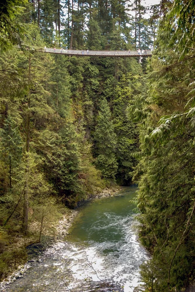 Vancouver, Canada - May 2007: People crossing the Capilano Suspension Bridge