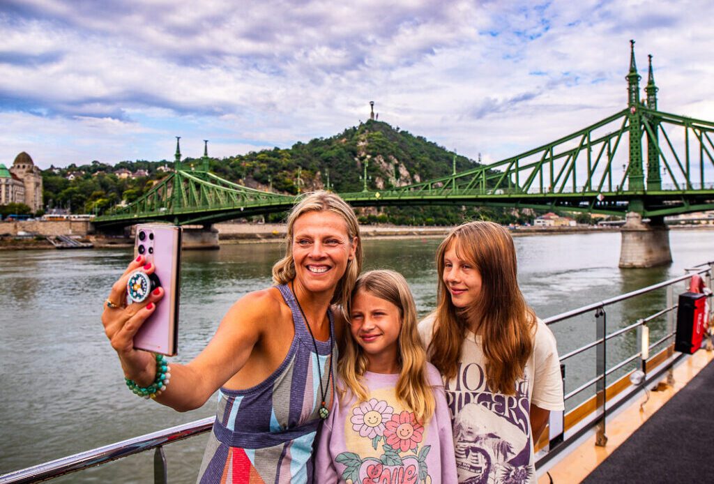 Mom taking a selfie photo with two daughters on a river cruise