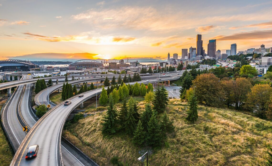 Seattle skylines and Interstate freeways converge with Elliott Bay and the waterfront background of in sunset time, Seattle, Washington State, USA.