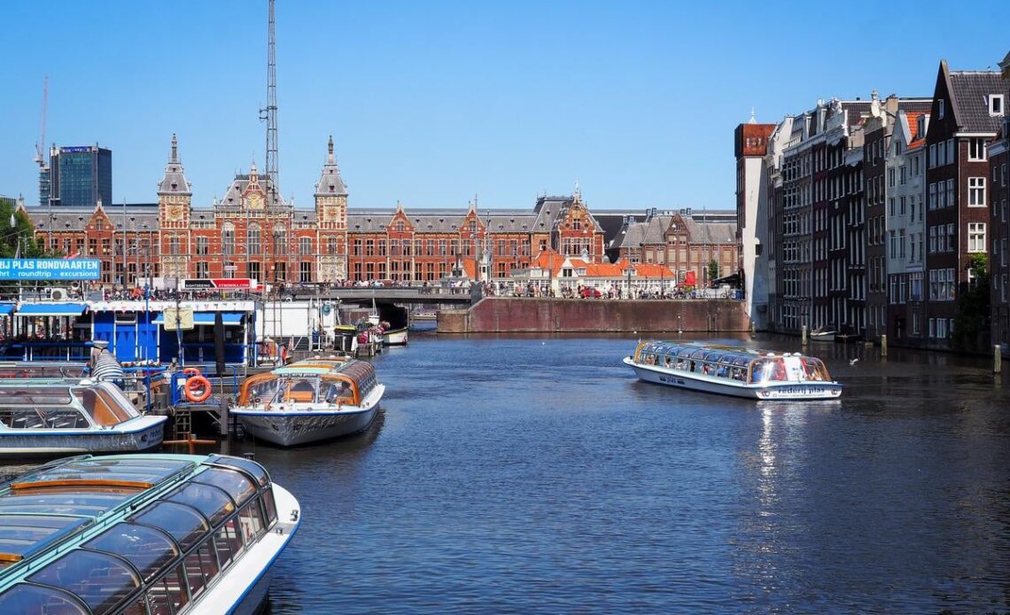 Damrak street view in Amsterdam - Dutch architecture and tourism