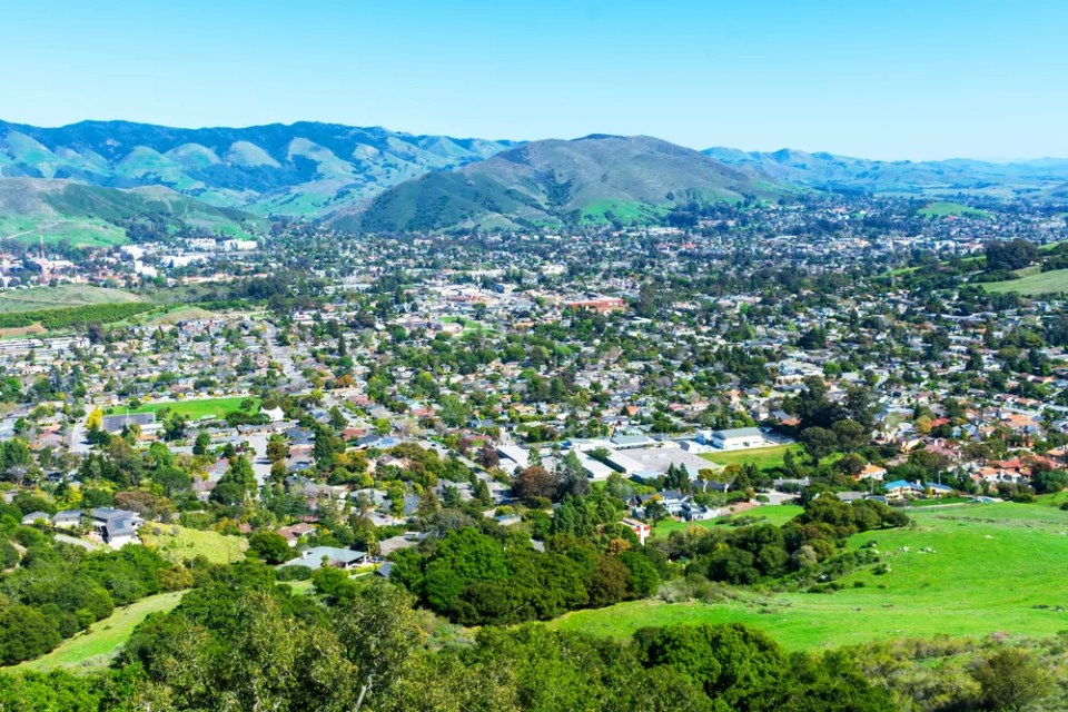 Elevated scenic view of San Luis Obispo urban area sprawl and green mountains of Santa Lucia Range from Bishop Peak