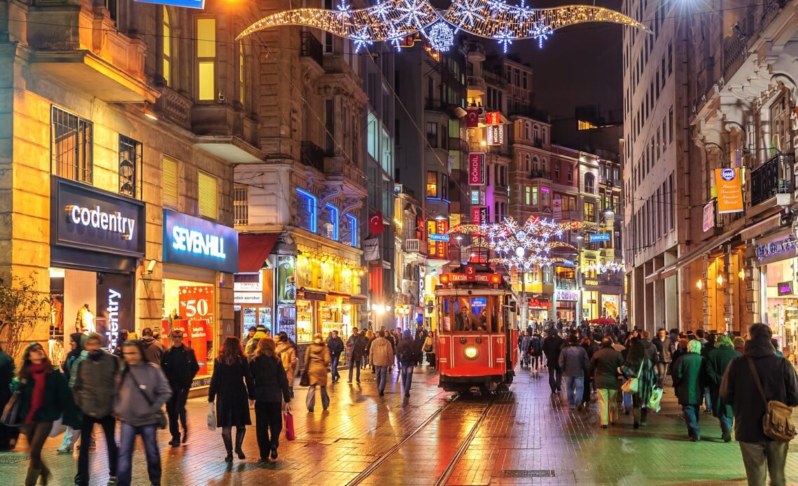 People walking on Istiklal Street in Beyoğlu, Istanbul with a tram running up the center