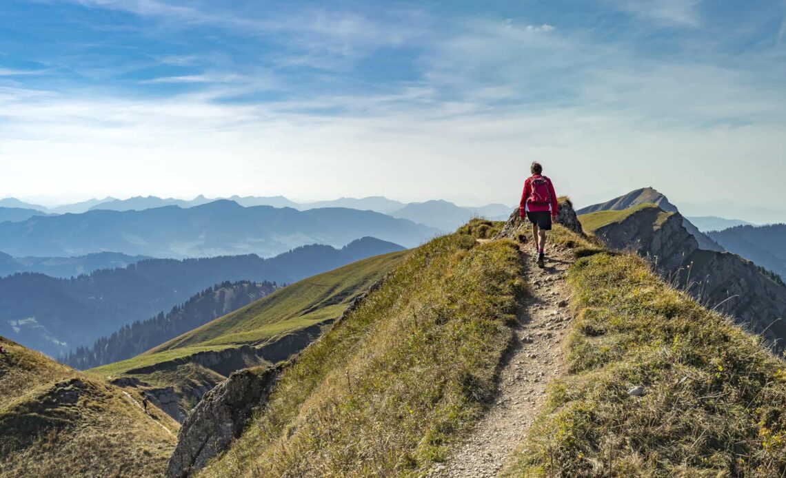 A woman hiking on a sunny day in the rugged mountains