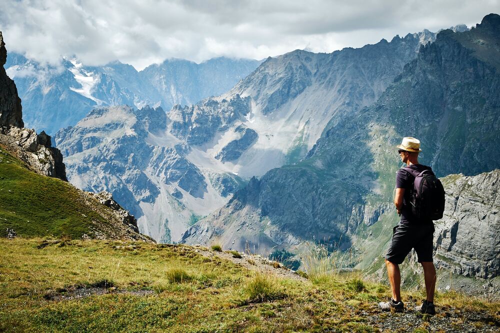 man looking at the alps on trail