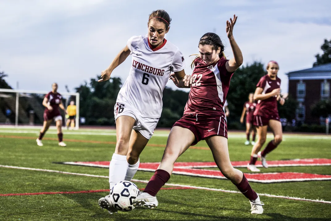 two soccer players battle for possession of the ball