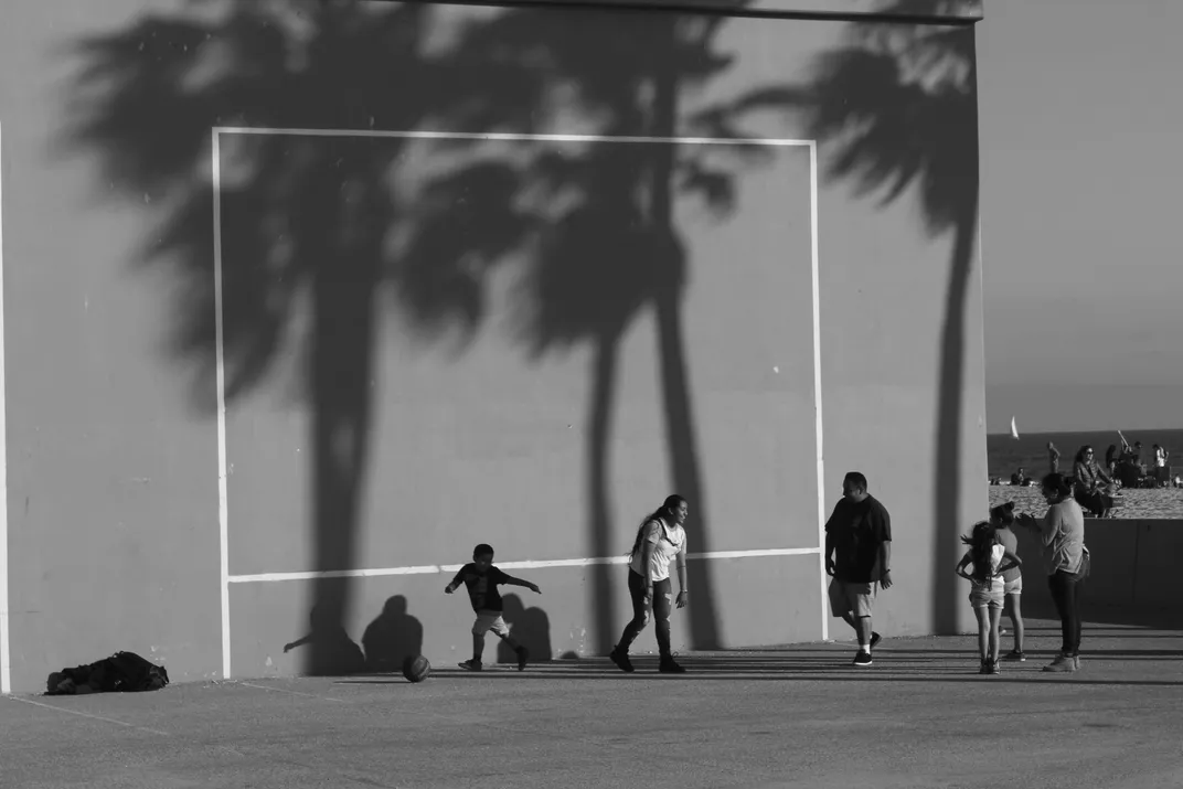 a black and white photo shows a family playing soccer