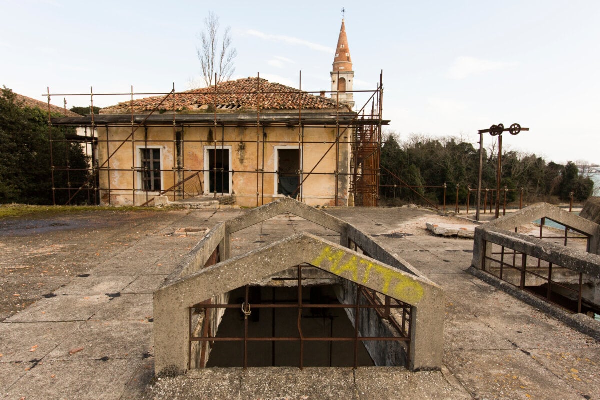 A landscape shot of Poveglia Island, as seen from one of its broken down buildings.