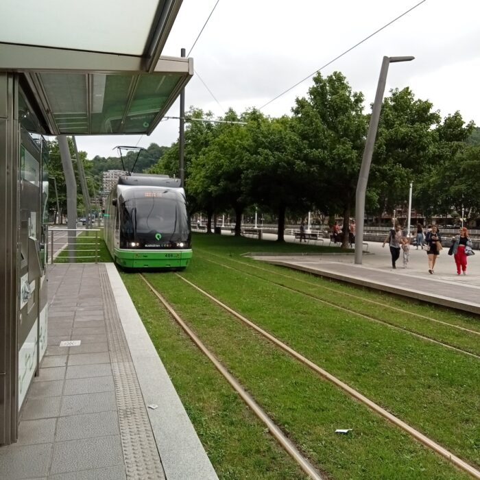 A tram car arrives at a stop by the esplanada