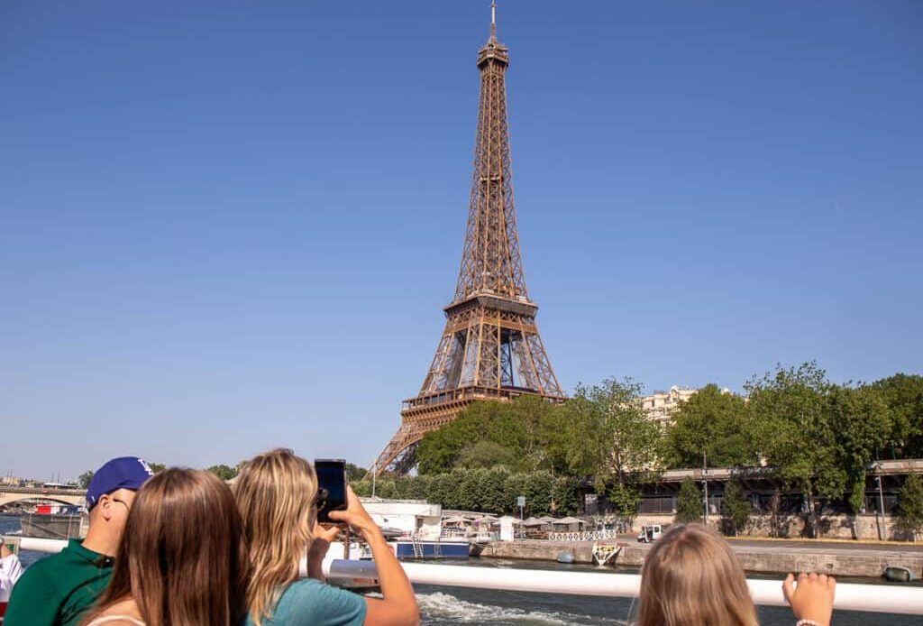 People looking up taking a photo of the Eiffel Tower in Paris