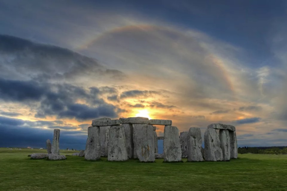 Image of Stonehenge  at sunset with beautiful solar sunset halo in vibrant colors. A halo is an optical phenomenon that appears  around the Sun and mostly caused by ice crystals  in the upper troposphere.