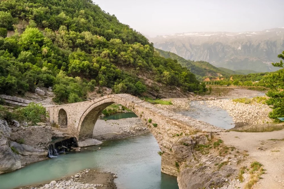 Benja Thermal Baths in Permet, Albania. Old arch shape stone bridge, river and pools with hot water in Albania.