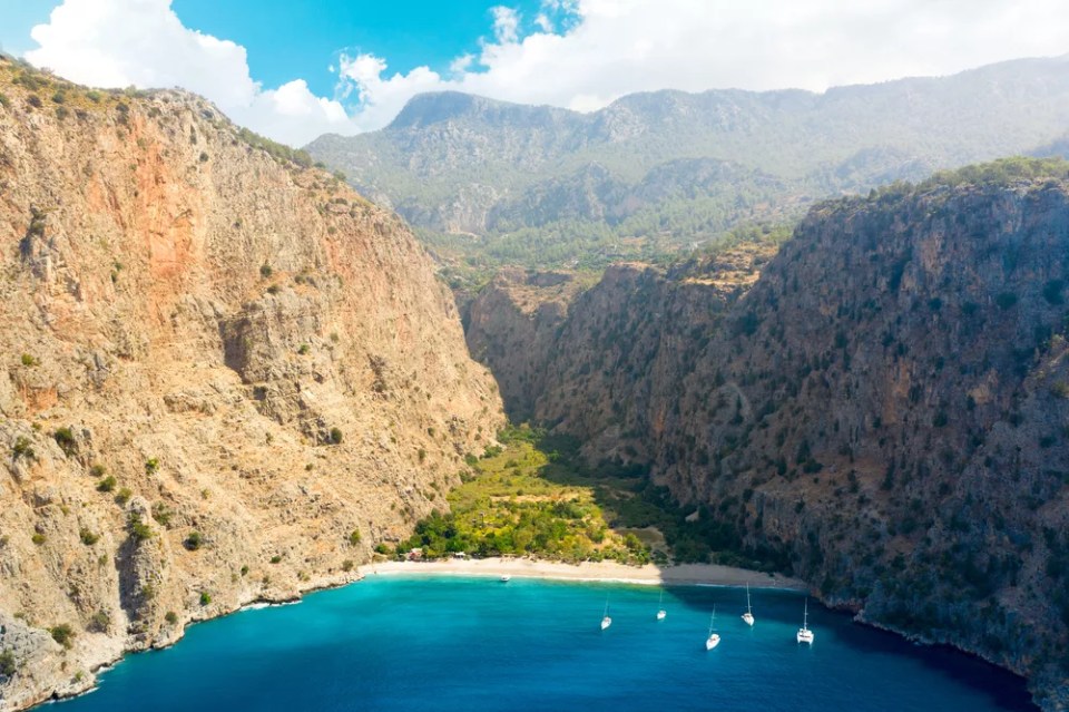 Aerial view over the clear beach and turquoise water of Butterfly Valley. In Turkish: Kelebekler Vadisi. Mugla Province, Turkey