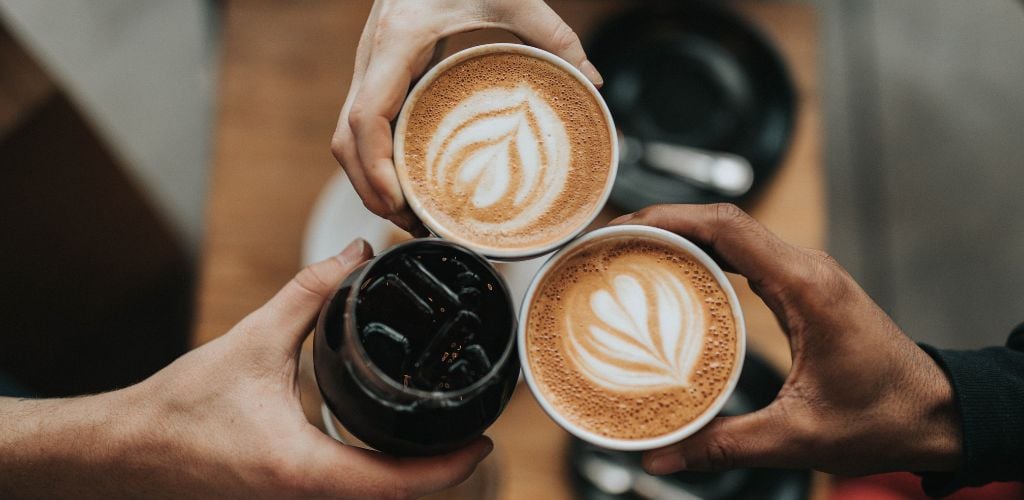 A group of friends toasting their coffees
