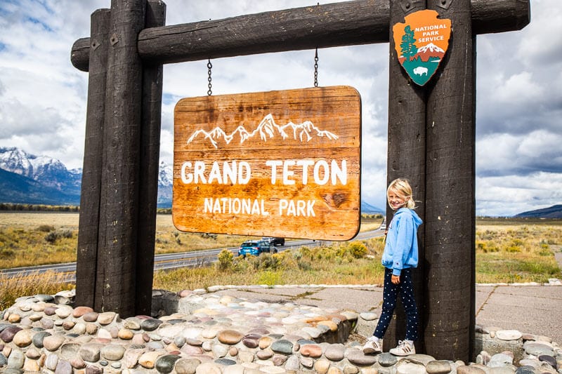 savannah standing at Entrance sign to Grand Tetons National Park