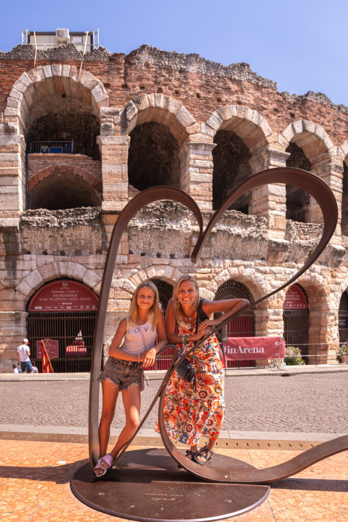 caz and savannah posing inside love heart sculpture in front of VErona arena