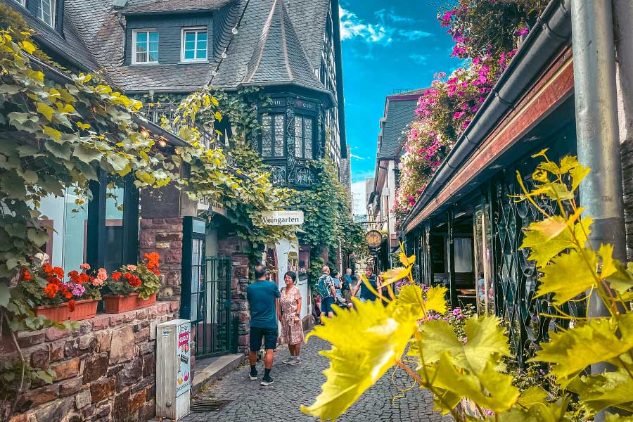 the Drosselgasse with people walking down it and traditional German half timbered buildings