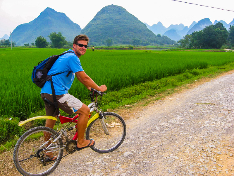 man on bicycle smiling at camera in yangshuo