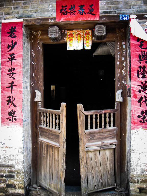 old wooden swing doors with red chinese characters up the side
