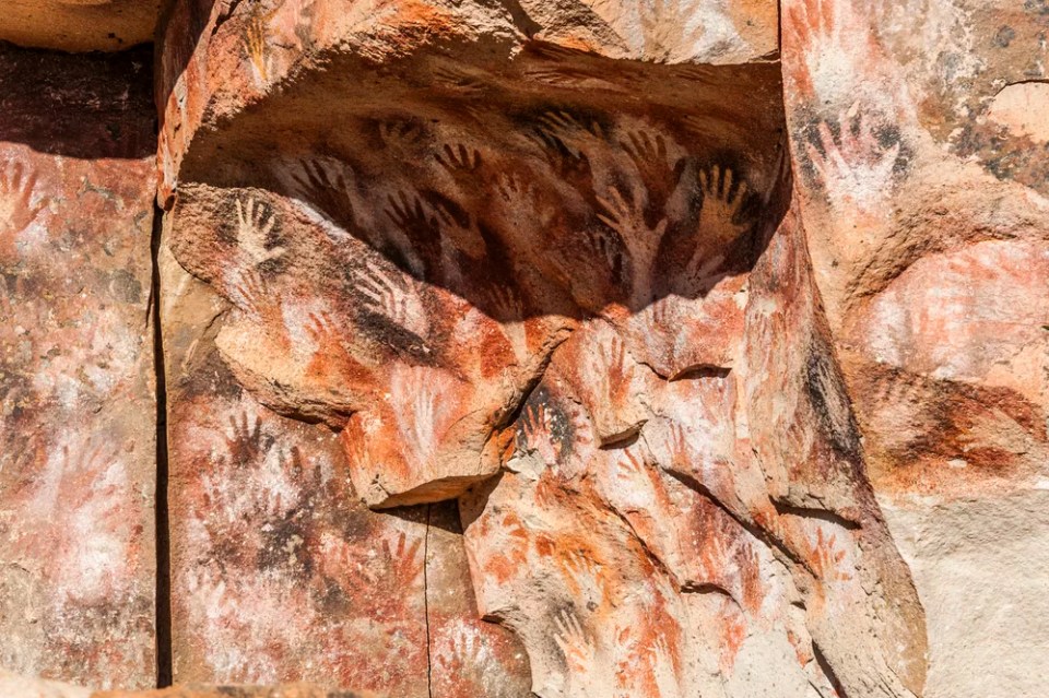 Paintings of ancient people in the Cave of the Hands (Spanish: Cueva de las Manos), Patagonia, Argentina