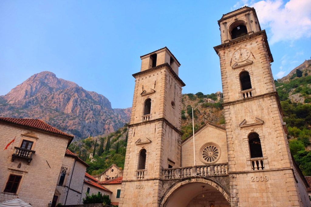 Kotor's twin church towers against a mountainous backdrop.