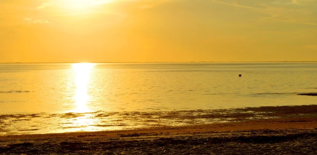 Ben T. Davis Beach-  a setting sun with rays reflecting the ocean