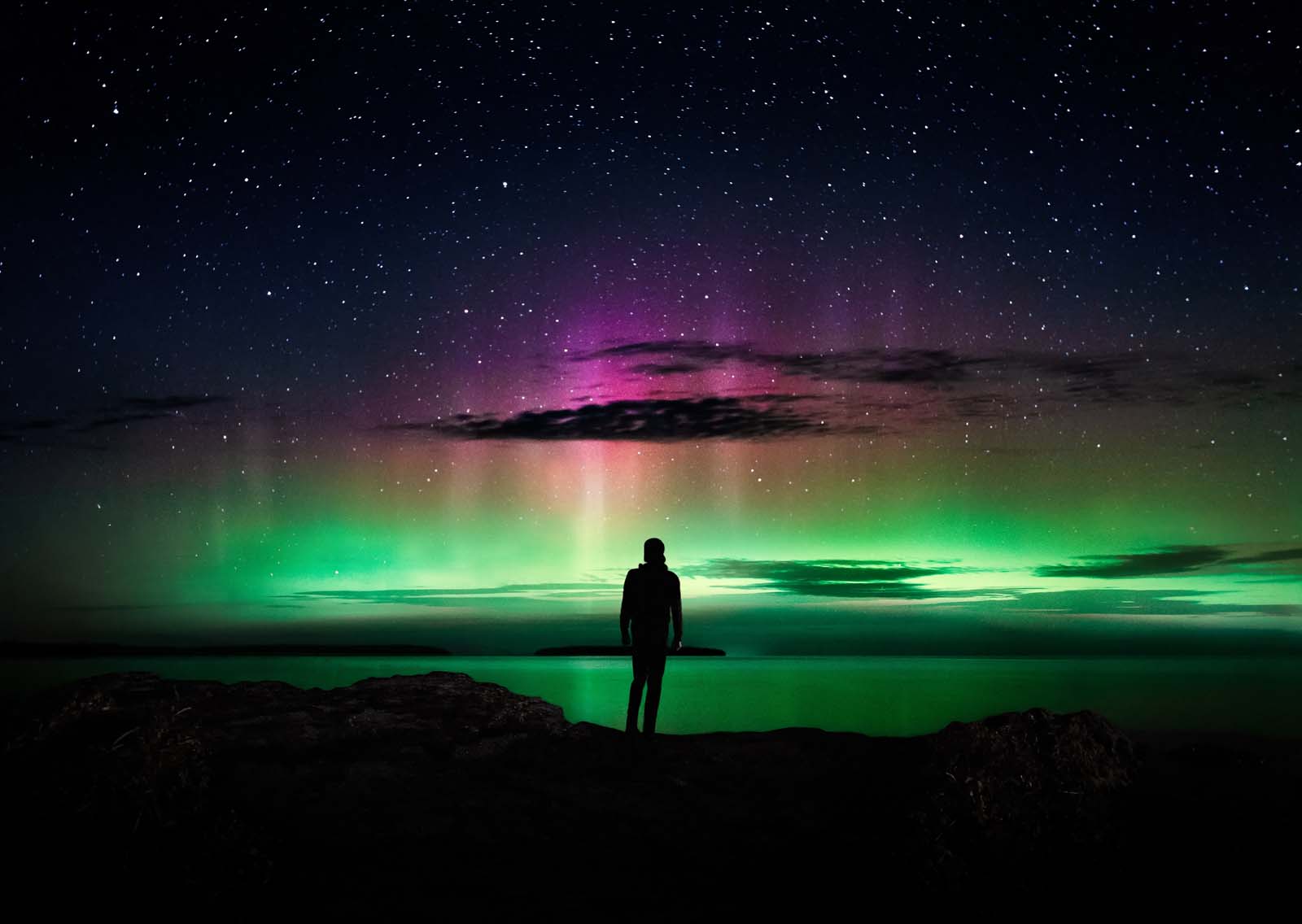 A person looking up at the night sky to see the Northern Lights in Ontario