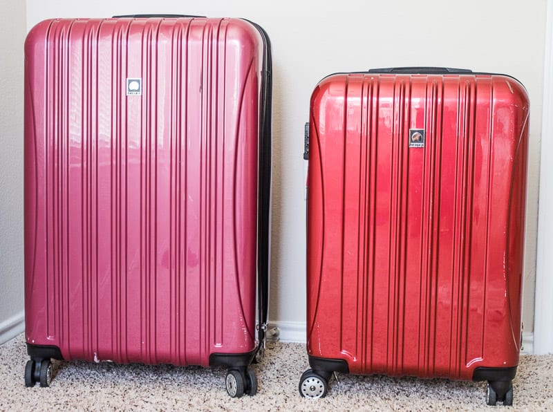 one small and large red desley suitcase sitting next to each other