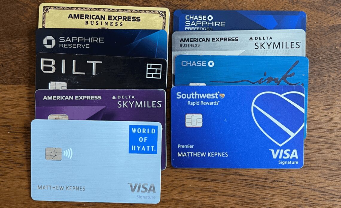 A variety of credit cards lined up on a wooden table