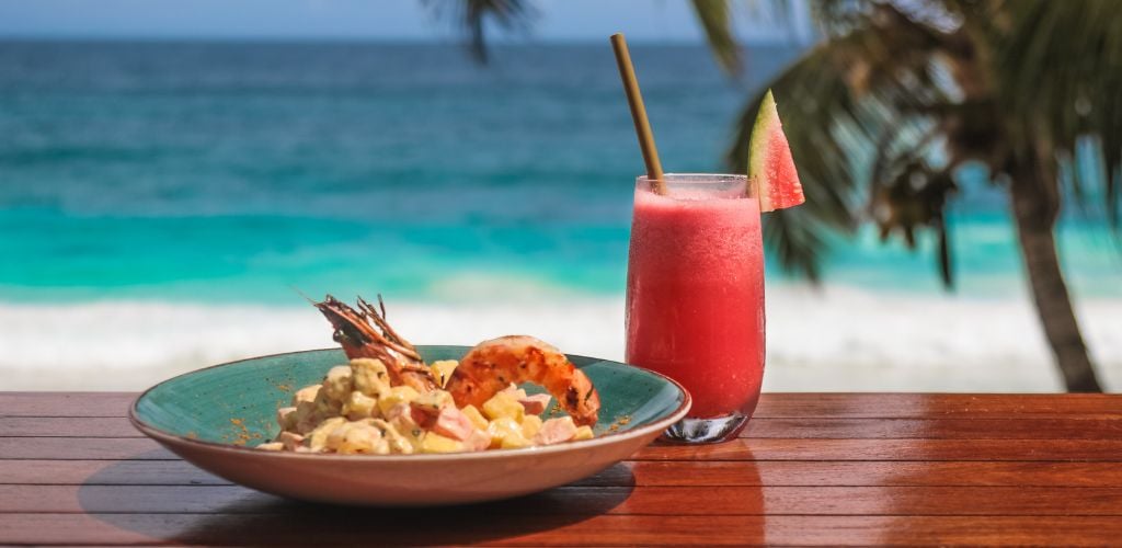 Seychelles Seafood lunch salad with prawn and coconut by the beach