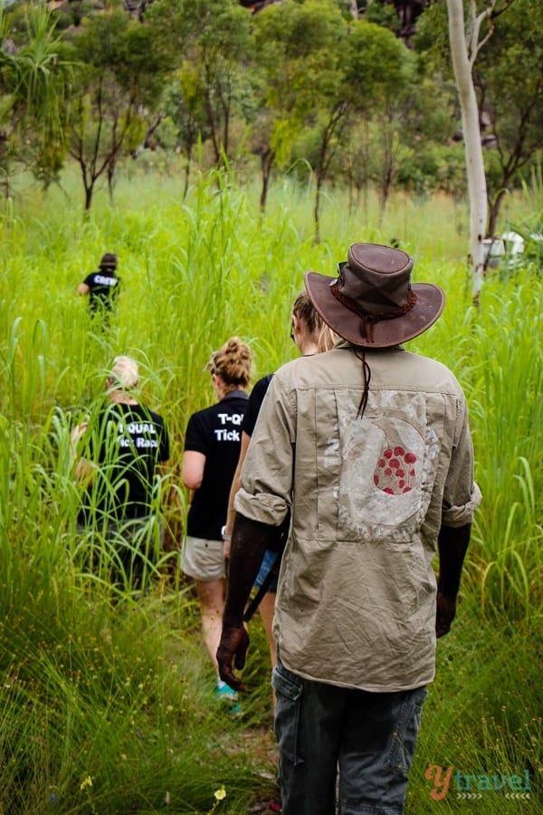 people walking through a grass field