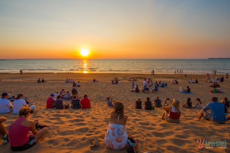 people on the beach watching the sunset