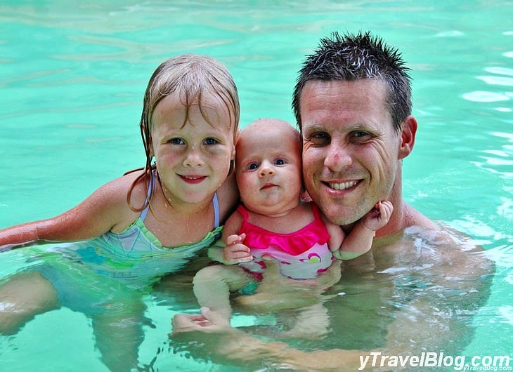 a man holding a baby and a little girl in a pool