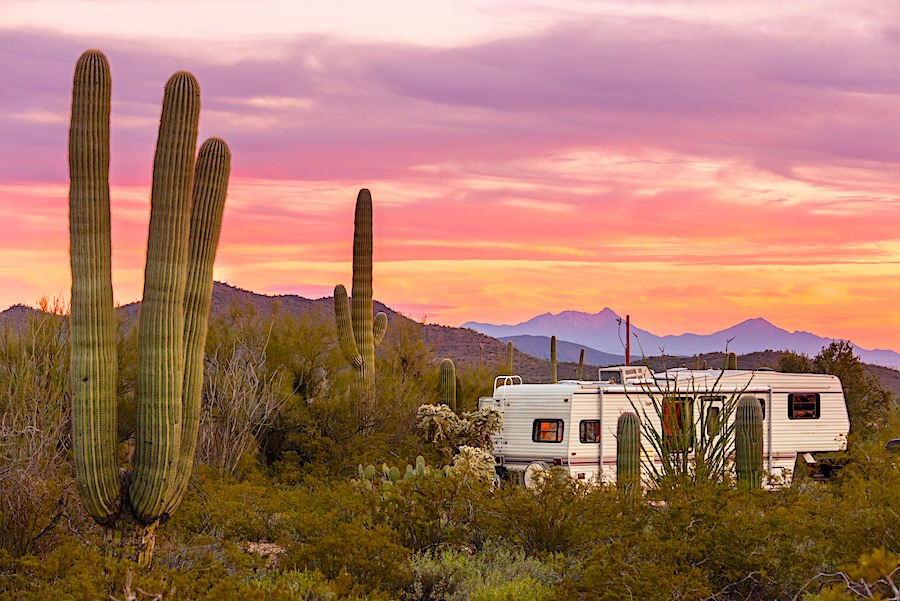 5th wheel parked in a remote desert setting with colorful sunset - full-time RVing