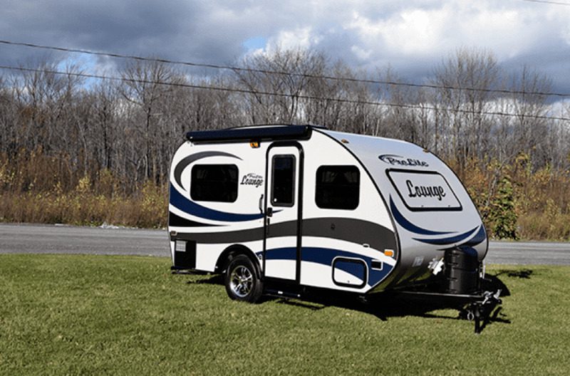 Small used travel trailer under 5000 lbs parked on a lawn