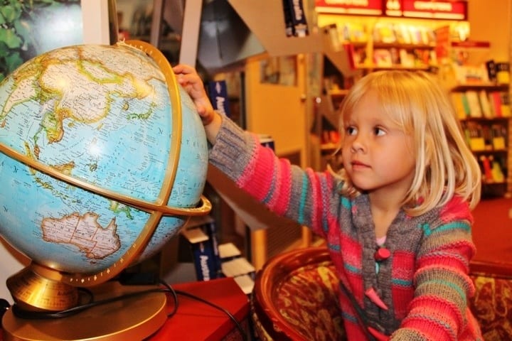 girl looking at a globe of the world