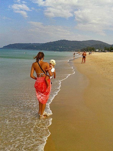 woman walking through the water on a beach