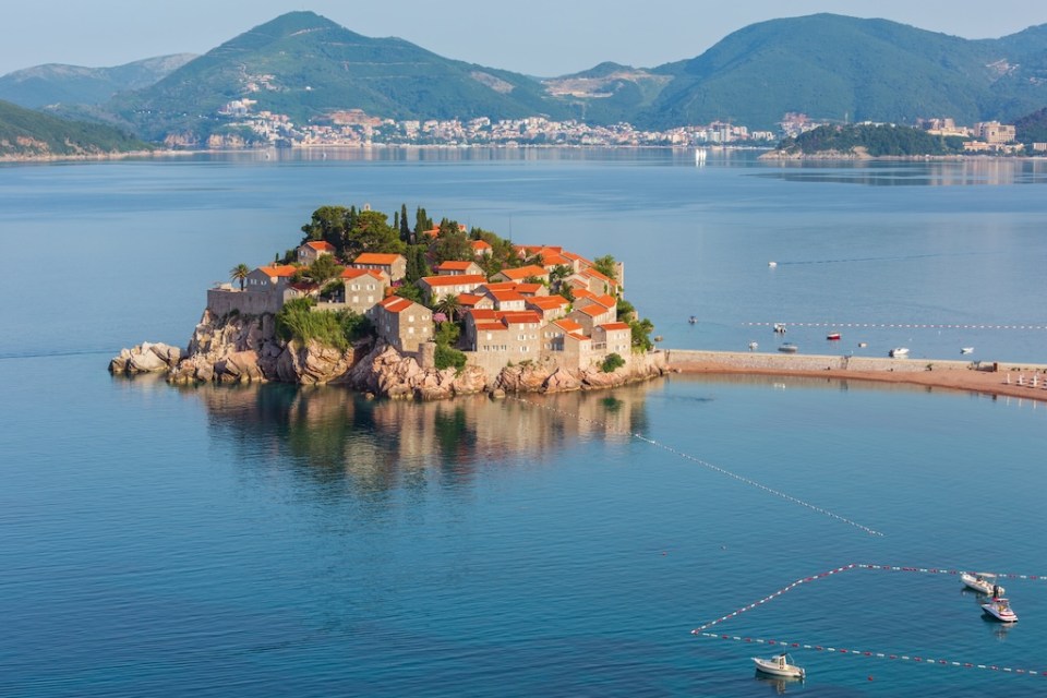 The morning view of Sveti Stefan sea islet with pink beach and town-hotel (Montenegro, near Budva)