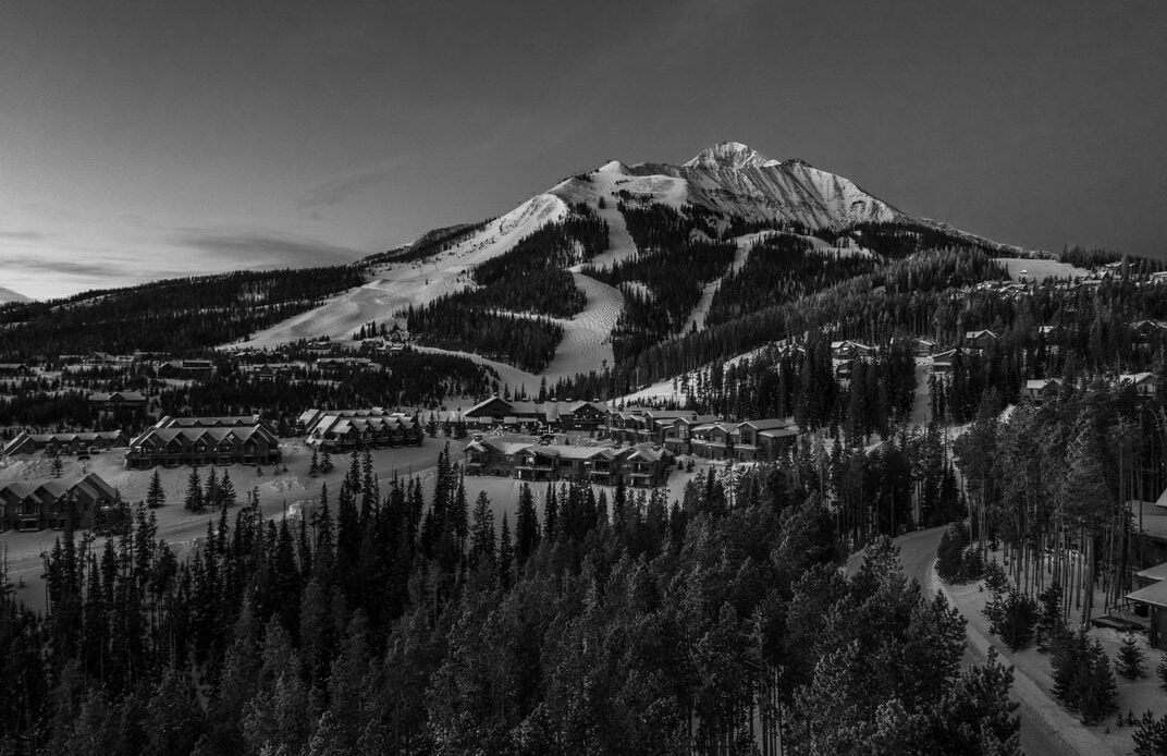 a ski resort at the base of a snow covered moutain