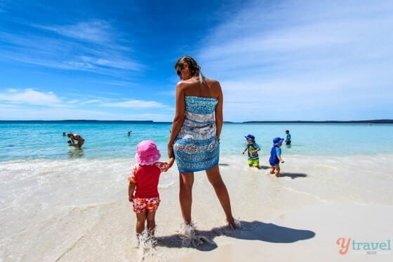 woman and a child holding hands on the beach