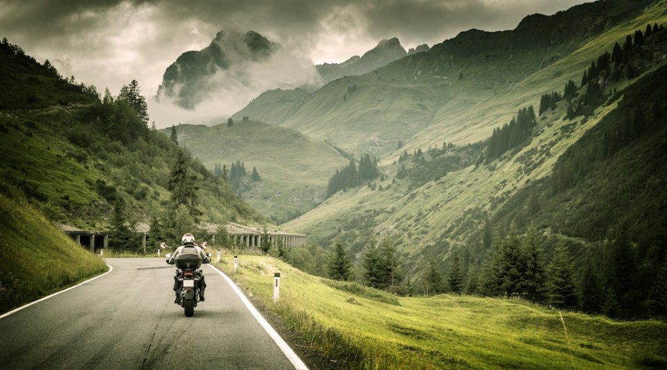 Motorcyclist on mountainous highway, cold overcast weather, Europe, Austria, Alps, extreme sport, active lifestyle, adventure touring concept