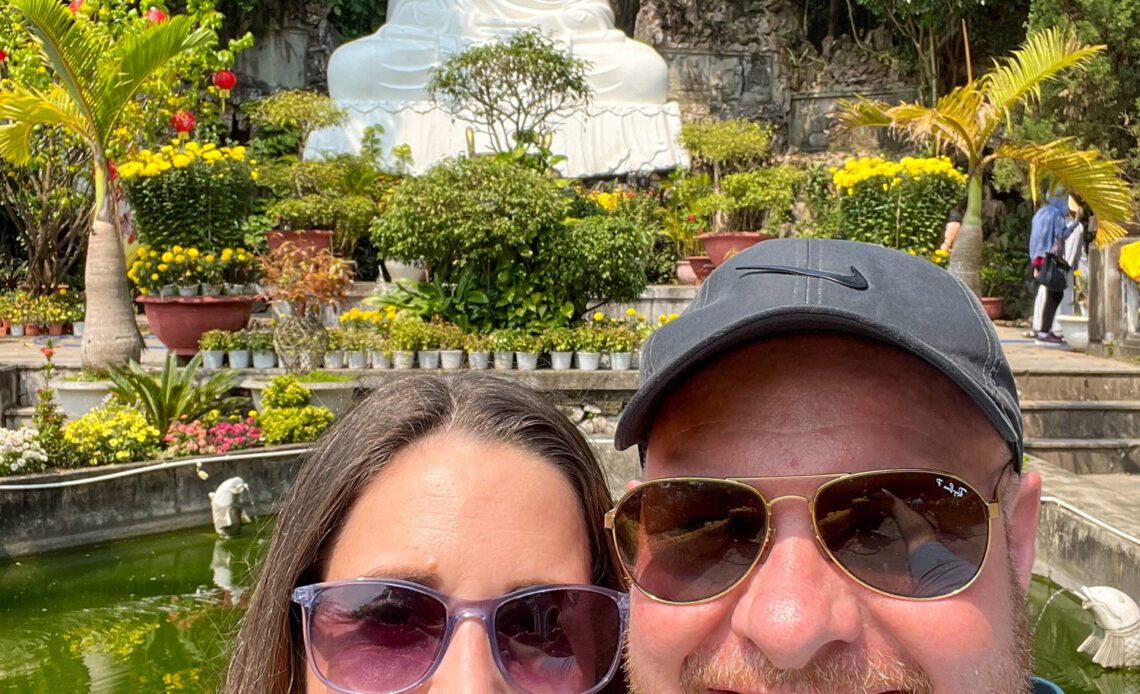 Dave and kel in front of a Buddha statue in the Marble Mountains of Central Vietnam, a top travel experience of 2023.